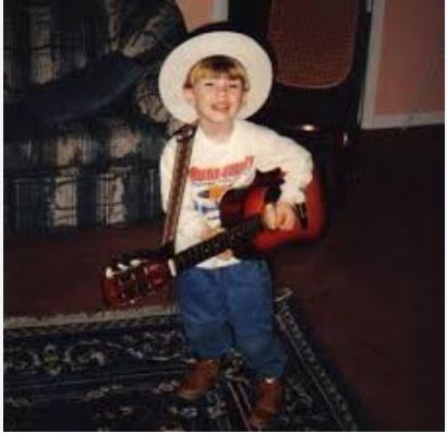  A young Morgan Wallen smiling, reflecting his early passion for music and his upbringing in Tennessee.